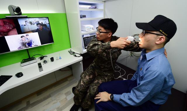 전북 어청도 해군부대 의무장이 국군의무사령부 군의관의 지시를 받아 장병을 진료하고 있다