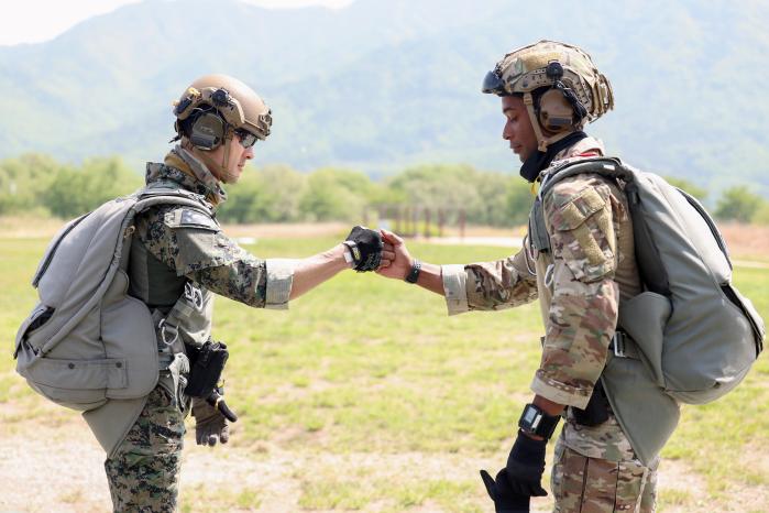 Soldiers from the 707th Special Missions Group (White Tiger) of the ROK Army Special Warfare Command and US Special Operations Command Korea (SOCKOR) check equipment and greet each other with fist bumps before starting a high-altitude friendship jump session to mark the 70th Anniversary of the ROK-U